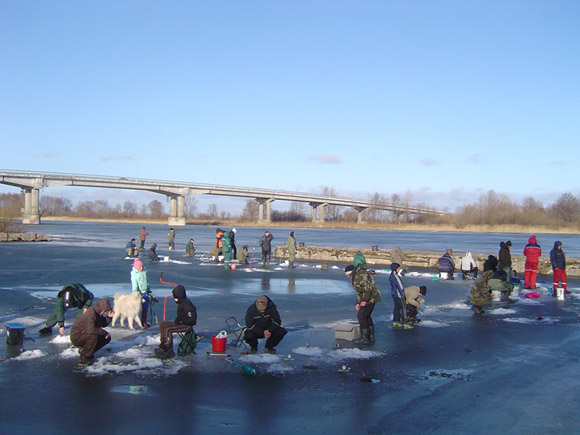 sekmadienio popietę poledinės žvejybos mėgėjai jau spietėsi ant Atmatos upės prieplaukos ledo ir traukė iš gilių ekečių sidabru spindinčias laibašones. (Oresto Lidžiaus nuotr.)